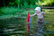 Wooden Toy Sailboat enjoyed by a small child in a pond